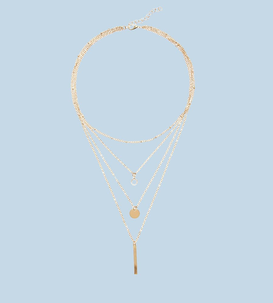 Dreireihige Halskette mit Kreis-, Plättchen- und Stabanhänger auf hellblauem Hintergrund