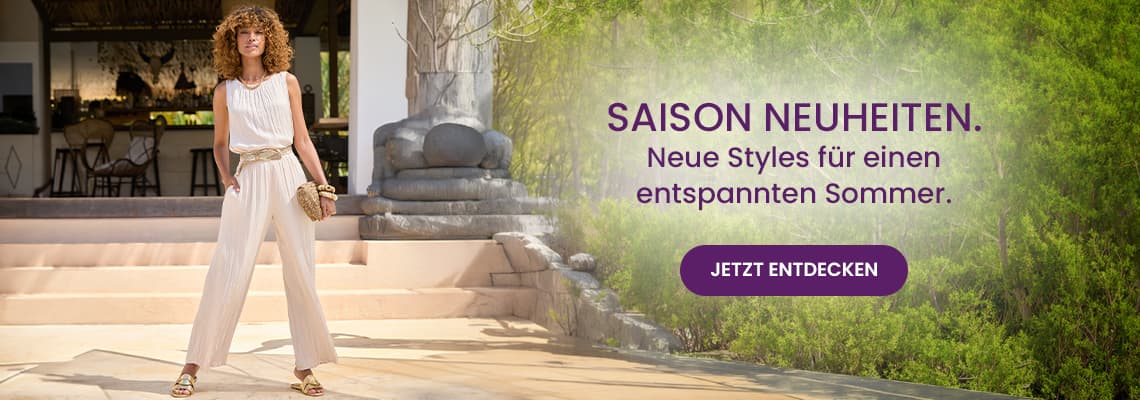 SAISON NEUHEITEN – Neue Styles für einen entspannten Sommer – Frau im hellen Jumpsuit steht vor Terrasse im Grünen