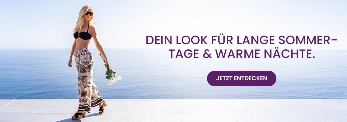 Dein Look für lange Sommertage & warme Nächte – Frau im Bikini-Top und Maxirock geht mit Blumen am Meer entlang