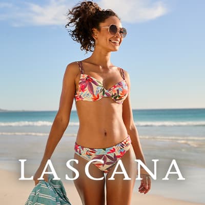 LASCANA – lachende Frau im bunten Bikini läuft mit Handtuch in der Hand am sonnigen Sandstrand entlang